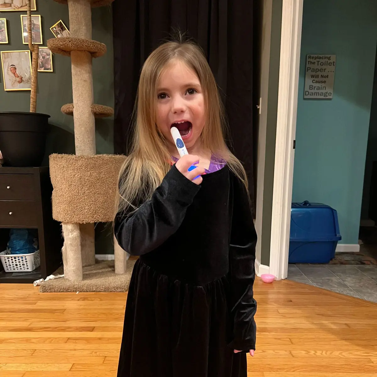 Child playfully using a thermometer in a cozy home setting.