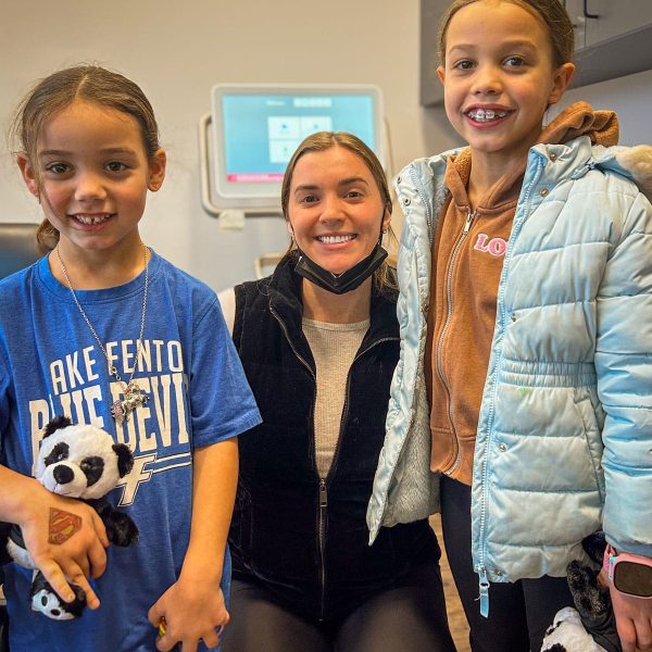 Orthodontist with two smiling children, sharing a happy moment at Dr. Wax Orthodontics.