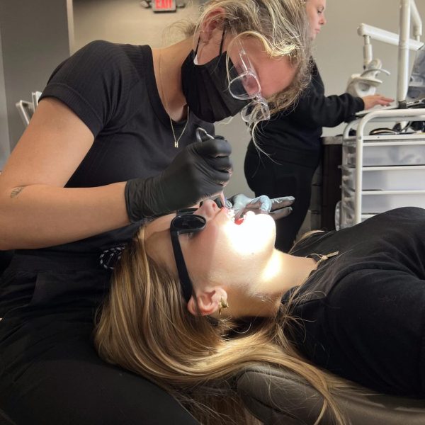 Orthodontist caring for a patient during a dental appointment, ensuring a comfortable experience.